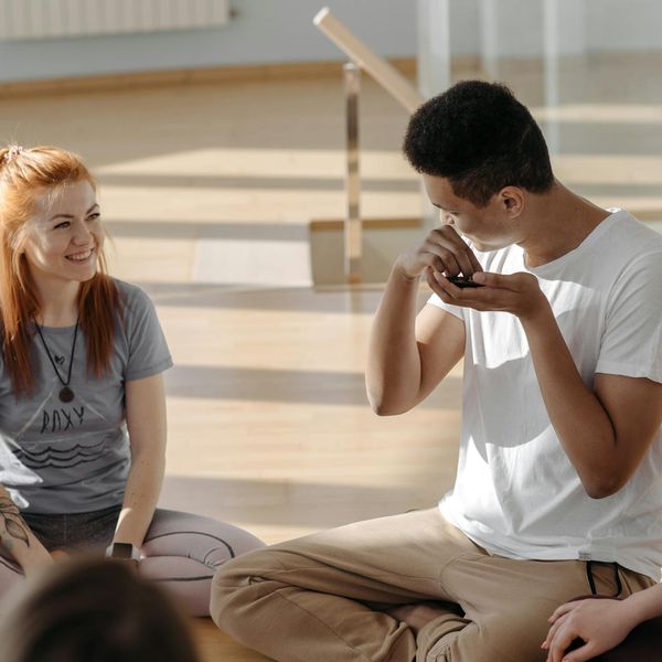 Group of diverse people sitting together in a comfortable yoga studio.