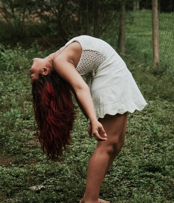 Woman in a dynamic yoga flow pose, surrounded by calm energy.